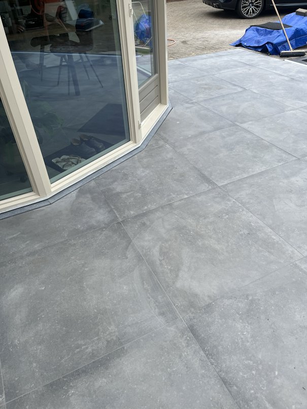 Detail van strak afgewerkt tegelwerk aan een schuifdeur — oog voor afwerking